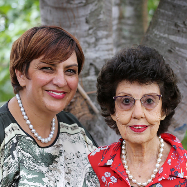 Centre owner, Janine and her mother Daphne standing outdoors, smiling.