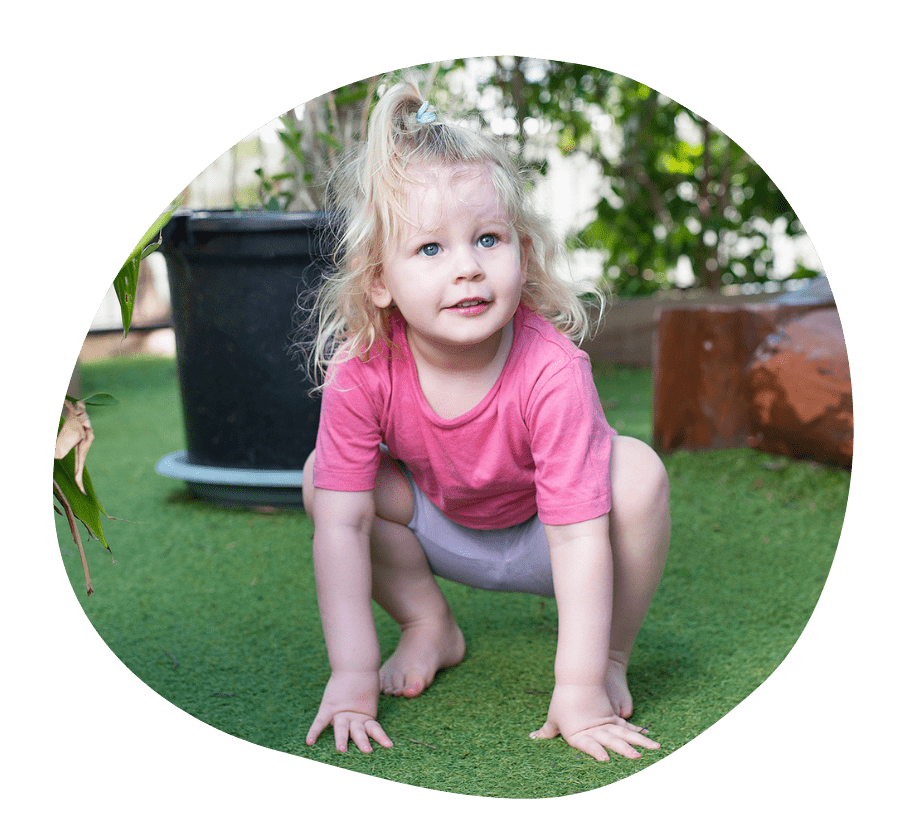 Two children smiling with glee on a small bridge in a playground